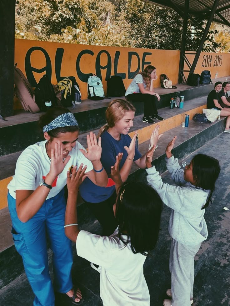 Volunteers playing high-five games with kids